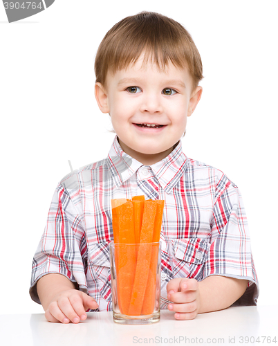Image of Little boy is eating carrot