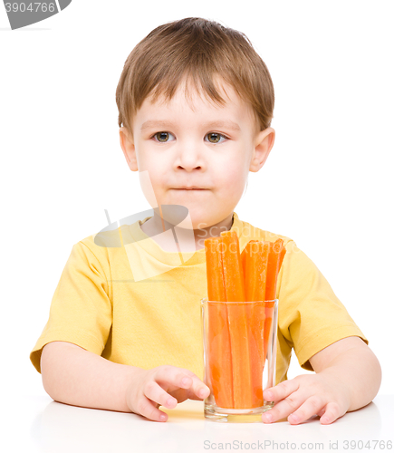 Image of Little boy is eating carrot