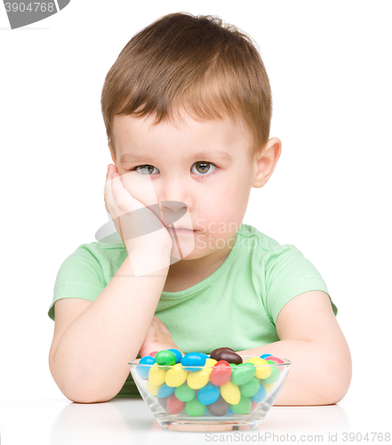 Image of Portrait of a sad little boy with candies