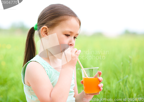 Image of Little girl is drinking orange juice