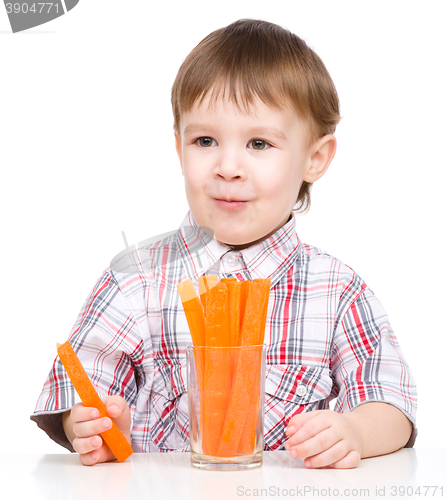 Image of Little boy is eating carrot
