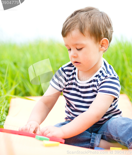 Image of Little boy is playing with toys