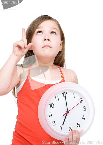 Image of Little girl is holding big clock