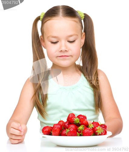 Image of Little girl is eating strawberries