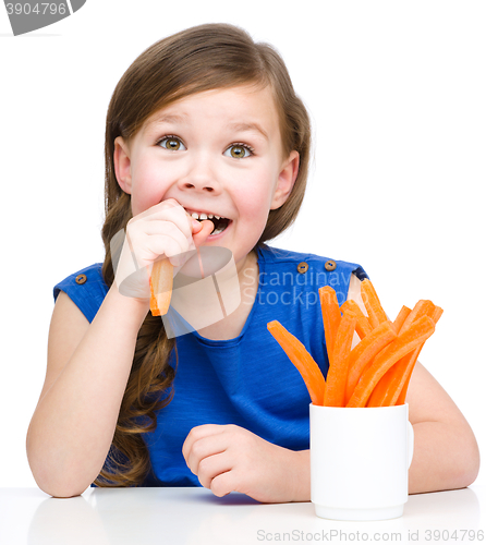 Image of Cute little girl is eating carrot