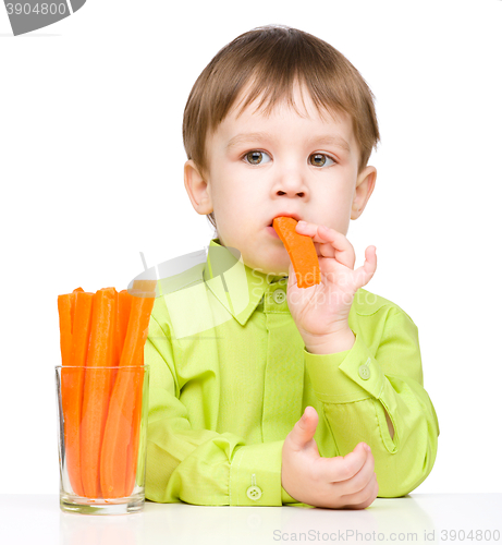 Image of Little boy is eating carrot
