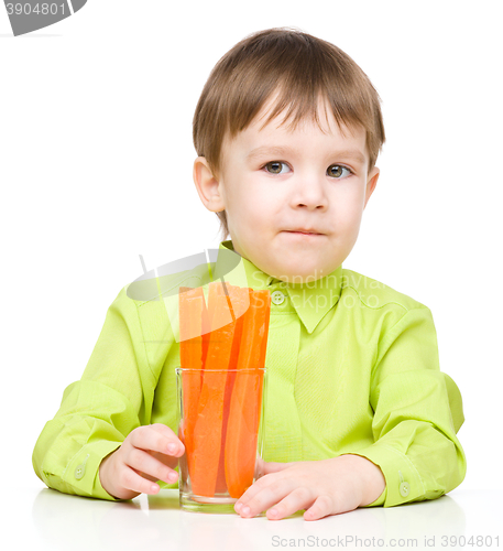 Image of Little boy is eating carrot
