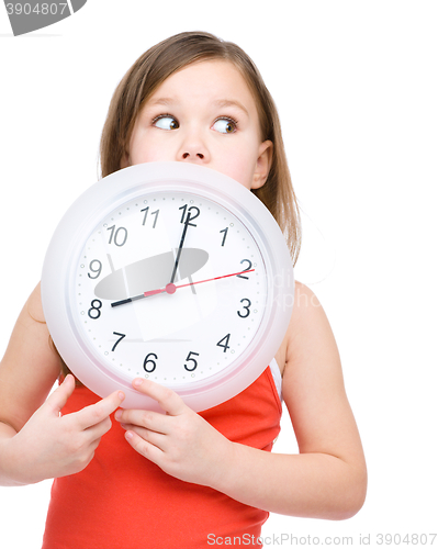 Image of Little girl is holding big clock