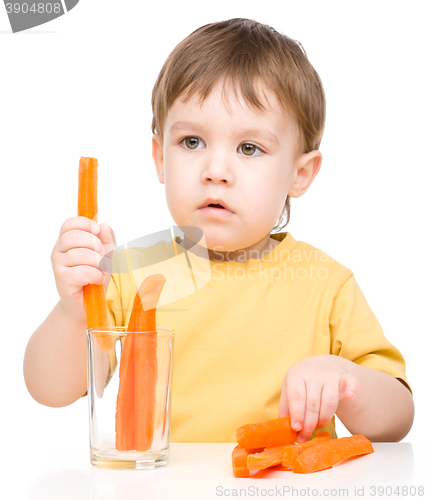 Image of Little boy is eating carrot