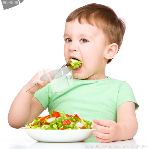 Image of Cute little boy is eating vegetable salad