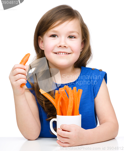 Image of Cute little girl is eating carrot