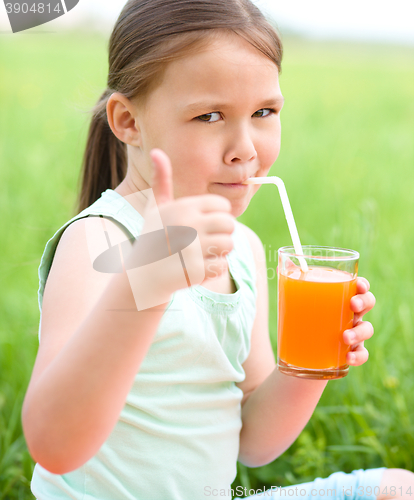 Image of Little girl is drinking orange juice