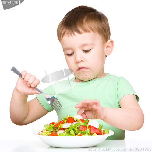 Image of Cute little boy is eating vegetable salad