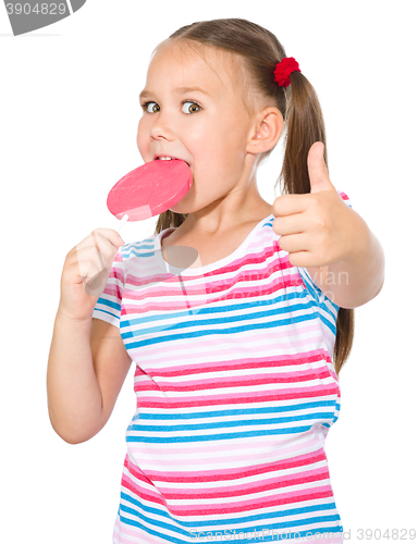 Image of Little girl with lollipop showing thumb up gesture