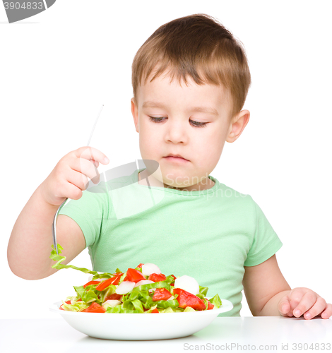 Image of Cute little boy is eating vegetable salad