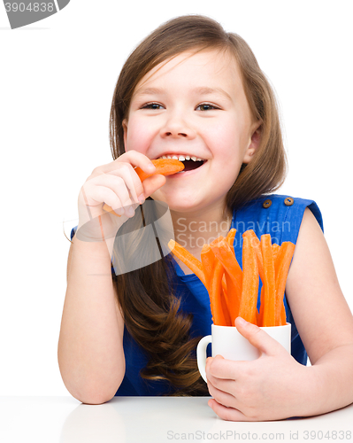 Image of Cute little girl is eating carrot