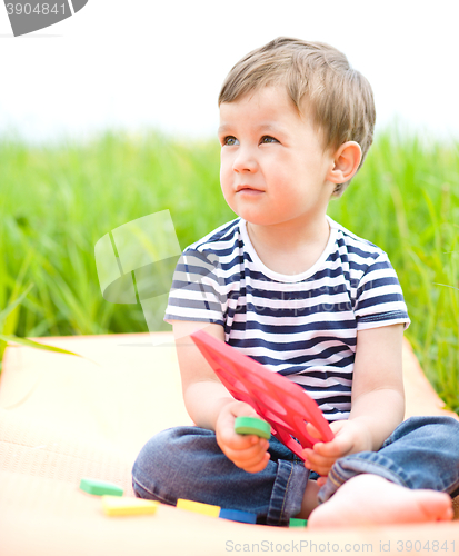 Image of Little boy is playing with toys