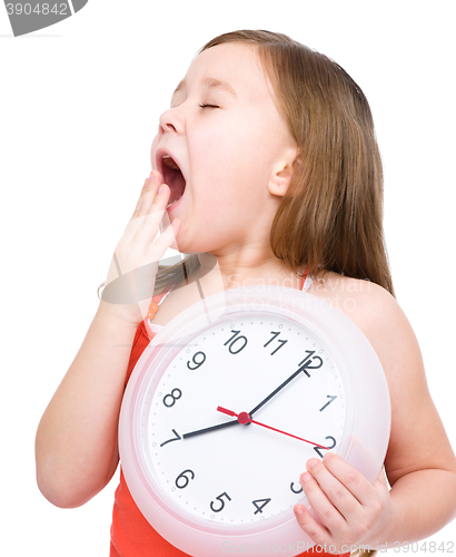 Image of Little girl is holding big clock