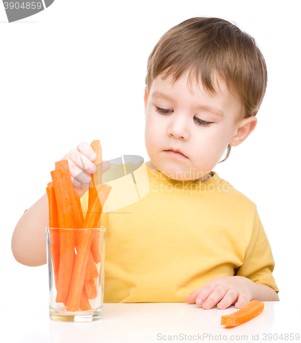 Image of Little boy is eating carrot