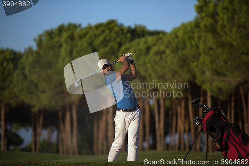 Image of golfer hitting a sand bunker shot on sunset