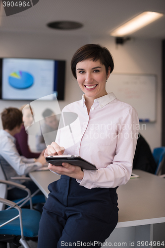 Image of hispanic businesswoman with tablet at meeting room