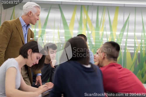 Image of teacher with a group of students in classroom