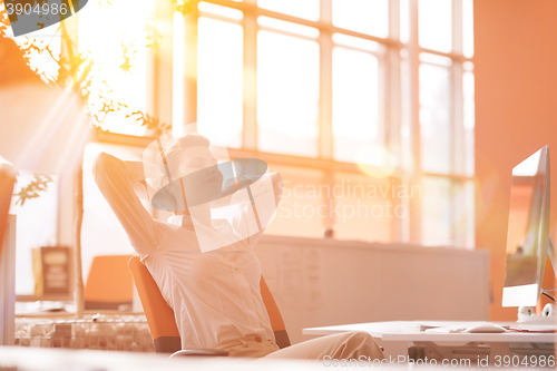 Image of young business woman relaxing at workplace