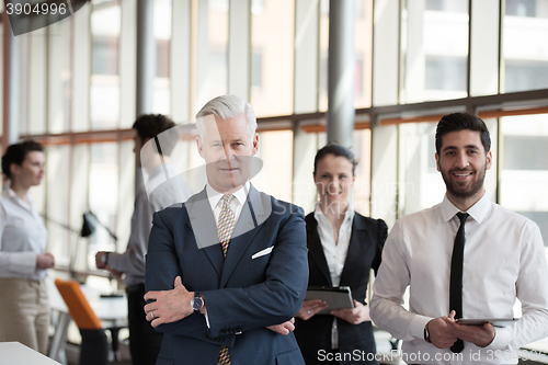 Image of portrait of senior businessman as leader  with group of people i