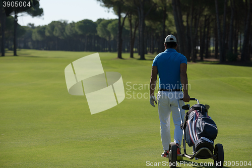 Image of golf player walking with wheel bag