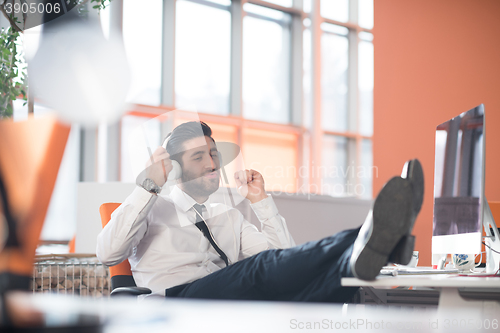 Image of relaxed young business man at office