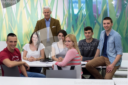 Image of portrait of  teacher with students group in background