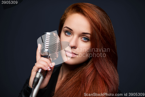 Image of Closeup of young woman with retro microphone