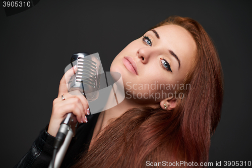 Image of Closeup of young woman with retro microphone