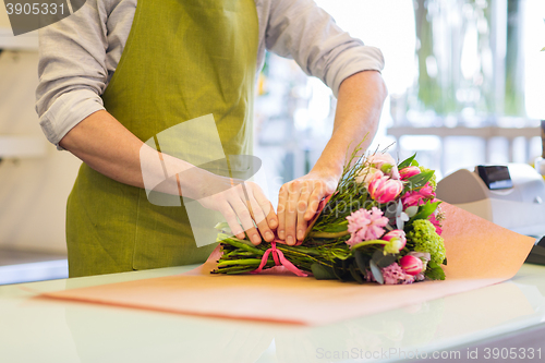 Image of florist wrapping flowers in paper at flower shop