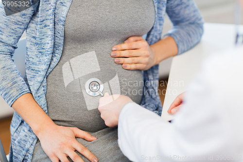 Image of doctor with stethoscope and pregnant woman belly