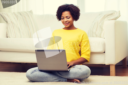 Image of happy african american woman with laptop at home