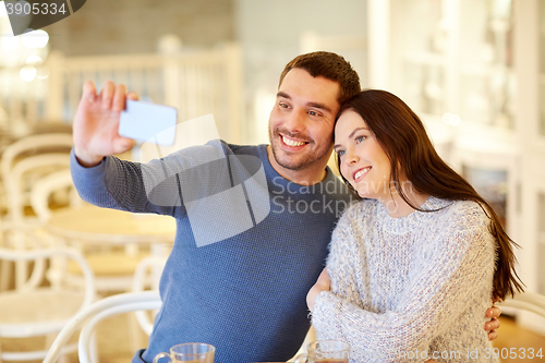 Image of couple taking smartphone selfie at cafe restaurant