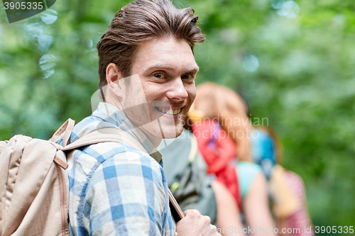 Image of group of smiling friends with backpacks hiking