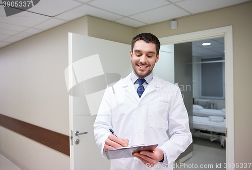 Image of smiling doctor with clipboard at hospital
