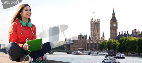 Image of happy young woman with tablet pc and headphones