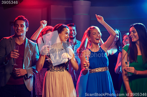 Image of happy friends with glasses of champagne in club