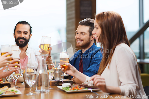 Image of friends dining and drinking beer at restaurant