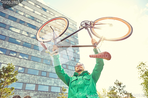 Image of young hipster man rising fixed gear bike in city