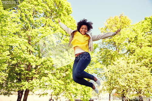 Image of happy african american young woman in summer park