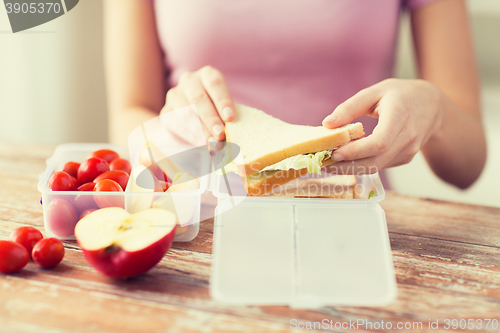 Image of close up of woman with food in plastic container