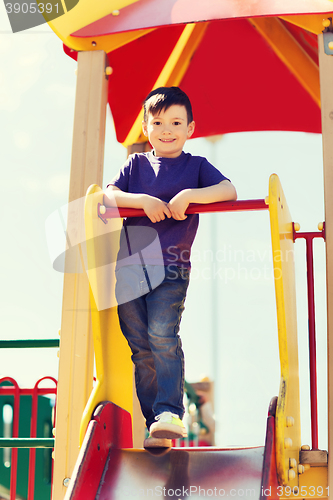 Image of happy little boy climbing on children playground