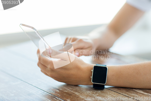 Image of close up of hands with smart phone and watch