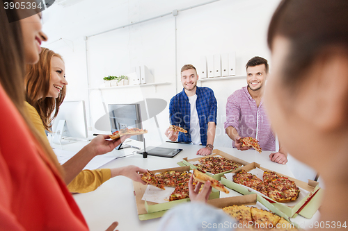 Image of happy business team eating pizza in office