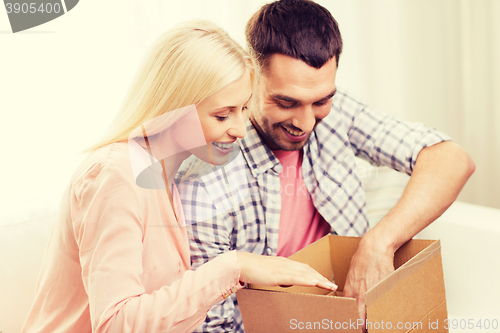 Image of happy couple with parcel box at home