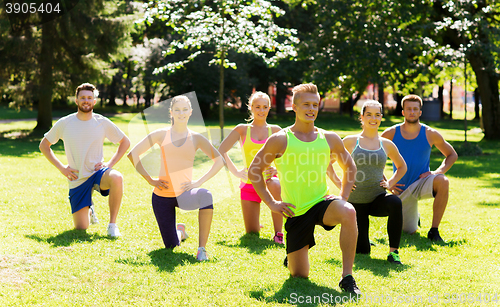 Image of group of friends or sportsmen exercising outdoors